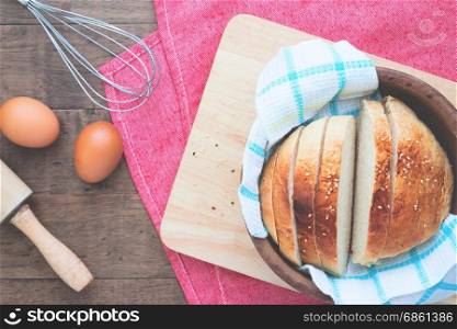 Sliced homemade bread with eggs on wood table with copy space, Flat lay