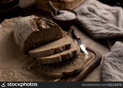 Sliced homemade bread with parchment paper on wood table. Bread at wooden tabletop as baking concept