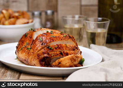 Sliced into slices baked turkey breast close-up at the dinner table