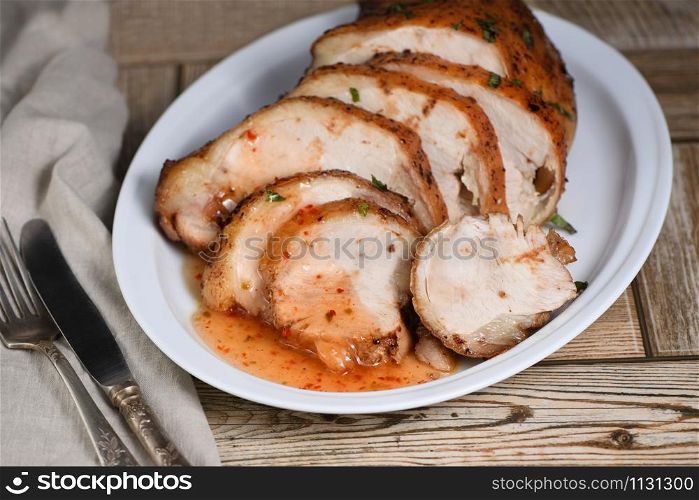 Sliced into slices baked turkey breast underneath sour- sweet sauce close-up