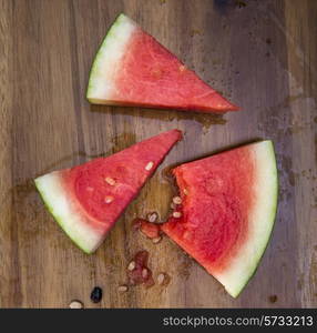 Sliced juicy watermelon on wooden chopping board in kitchen