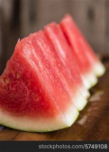 Sliced juicy watermelon on wooden chopping board in kitchen