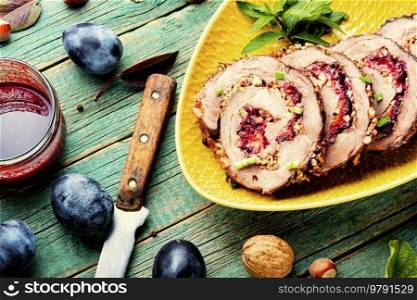 Sliced meatloaf stuffed with plums. Autumn meat recipe. Roast pork with prunes. Juicy roasted porchetta with plums