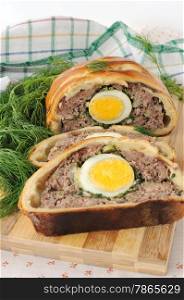 Sliced meatloaf with egg and herbs baked in pastry