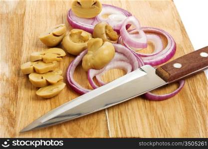 sliced mushrooms and onions on a cutting board