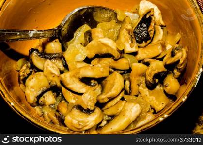 sliced mushrooms in dish with spoon on a table