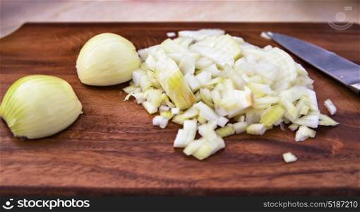 Sliced onions on a cutting board to prepare meals. Chopped onions on wooden cutting board. Bulb onion is good for health.