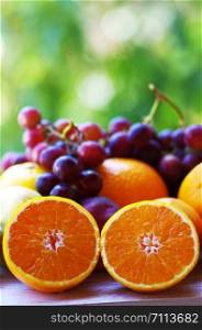sliced oranges and grapes, green background