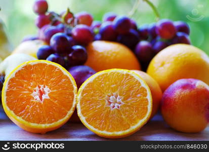 sliced oranges, nectarine and grapes on table