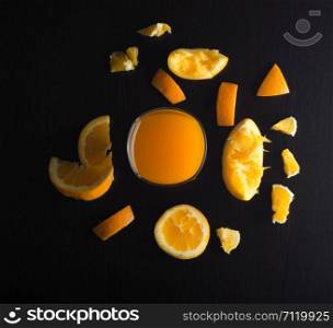 Sliced oranges with glass on black background