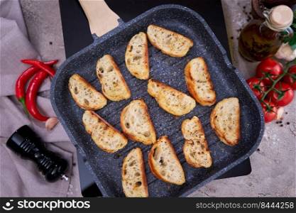 sliced pieces of baguette on grill frying pan.. sliced pieces of baguette on grill frying pan