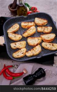 sliced pieces of baguette on grill frying pan.. sliced pieces of baguette on grill frying pan