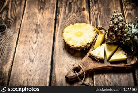 Sliced pineapple on the Board. On a wooden table.. Sliced pineapple on the Board.