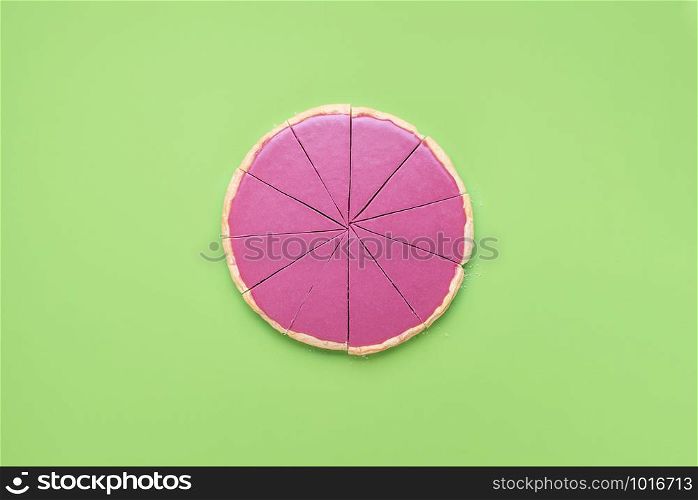 Sliced pink chocolate pie on a green background. Above view swiss ruby chocolate mousse in pie crust. Christmas chocolate tart. Xmas pink dessert.