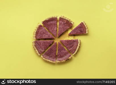 Sliced pink pie with cranberry curd and one slice separated on a yellow background. Flat lay of delicious berries tart. Thanksgiving pink pie.