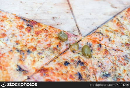 Sliced Pizza on a wooden cutting board, selective focus