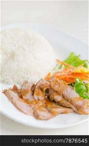 sliced pork tenderloin with fresh salad served with steamed rice. pork and rice