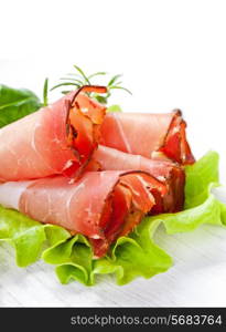 Sliced prosciutto in white wooden background