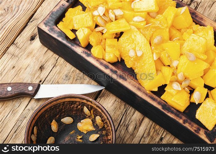 Sliced pumpkin on wooden background.Autumn vegetarian cooking. Sliced pumpkin on kitchen board