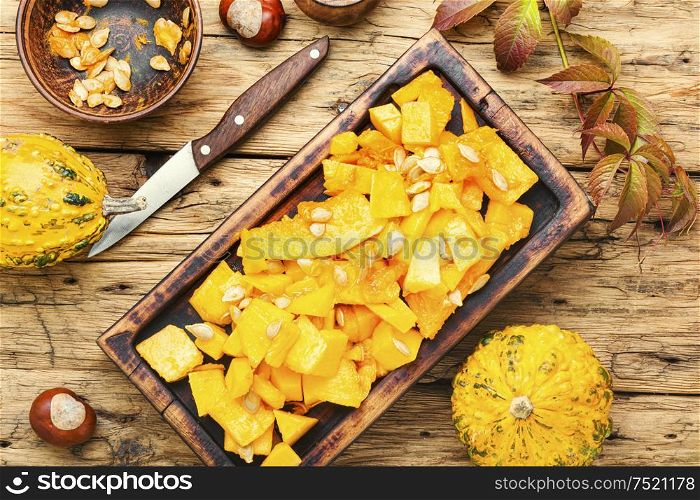 Sliced pumpkin on wooden background.Autumn vegetarian cooking. Sliced pumpkin on kitchen board