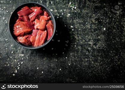 Sliced raw liver in a bowl. On a black background. High quality photo. Sliced raw liver in a bowl. 