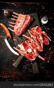 Sliced raw rack lamb. Against a dark background. High quality photo. Sliced raw rack lamb. Against a dark background.
