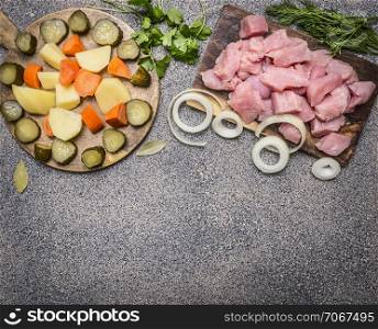 sliced raw turkey with potatoes, carrots and pickles, ingredients for stew border ,place for text on wooden rustic background top view close up
