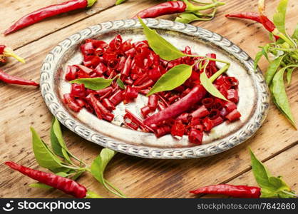 Sliced red hot chili peppers on on wooden background. Paprika powder and chili peppe