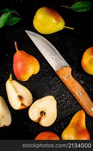 Sliced ripe pear with a knife. On a black background. High quality photo. Sliced ripe pear with a knife.