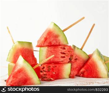 sliced ripe red watermelon with seeds on a wooden white cutting board, summer berry