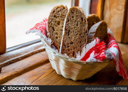 sliced rye bread in the basket on the windowsill in the farmhouse