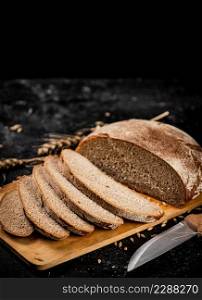 Sliced rye bread on a cutting board. On a black background. High quality photo. Sliced rye bread on a cutting board.