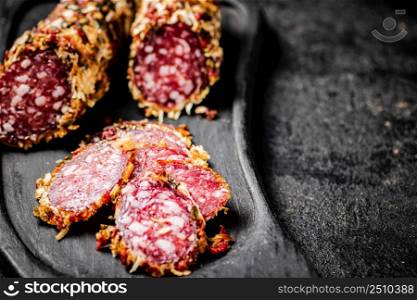 Sliced salami sausage. On a black background. High quality photo. Sliced salami sausage. On a black background.