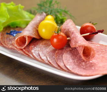 Sliced Salami with tomatoes and salad leaves