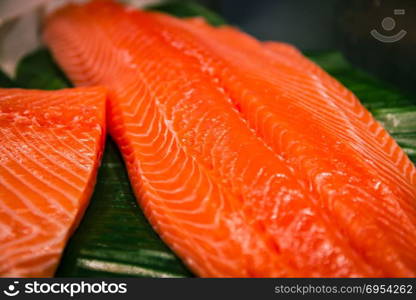 Sliced salmon laid on a green surface.