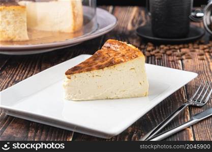 Sliced san sebastian cheesecake with coffee on wooden table