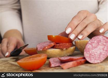 sliced sausage and tomatoes with bread, while preparing a sandwich at home, Eastern Europe. sliced sausage and tomatoes