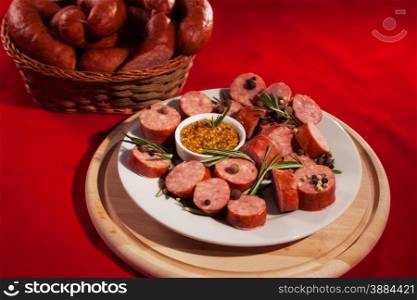sliced sausages on a plate with rosemary and pepper
