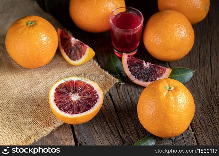 Sliced Sicilian Blood oranges fruits over old dark wooden background. Top view.