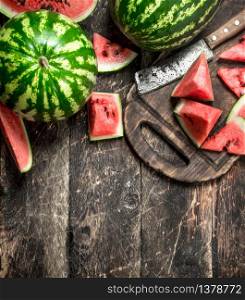 Sliced slices of ripe watermelon on a board. On a wooden background.. Sliced slices of ripe watermelon on a board.