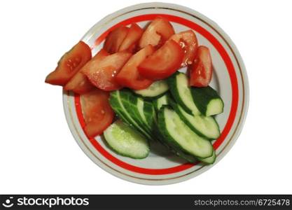 Sliced tomatoes and cocumbers on the round plate isolated on the white background