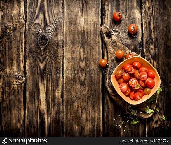 Sliced tomatoes in a Cup on the Board. On wooden background.. Sliced tomatoes in a Cup on the Board.