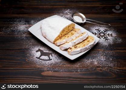 Sliced Traditional Christmas stol≤n cake with marzipan and dried fruit on wooden background. High quality photo. Sliced Traditional Christmas stol≤n cake with marzipan and dried fruit on wooden background