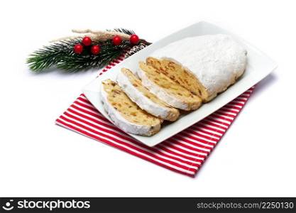 Sliced Traditional Christmas stollen cake with marzipan and dried fruit isolated on ceramic plate. High quality photo. Sliced Traditional Christmas stollen cake with marzipan and dried fruit isolated on ceramic plate