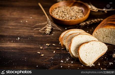 Sliced wheat bread. On a wooden background. High quality photo. Sliced wheat bread. On a wooden background.