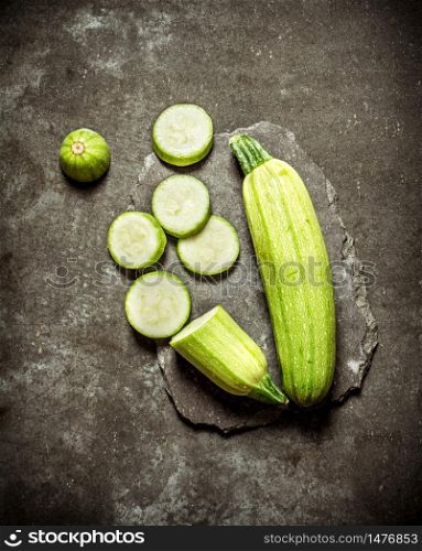 Sliced zucchini on a stone stand. On a stone background.. Sliced zucchini on a stone stand.
