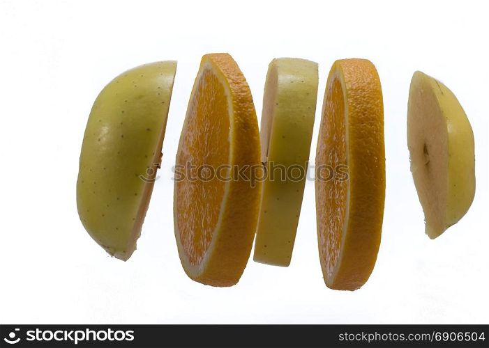 Slices of apples and orange hang . Slices of apples and orange hang on a white background