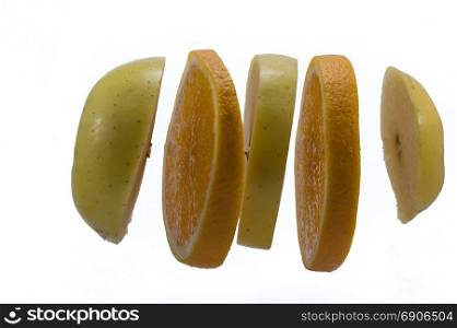Slices of apples and orange hang . Slices of apples and orange hang on a white background