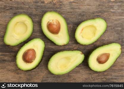 Slices Of Avocado Cut In Half On Wooden Table
