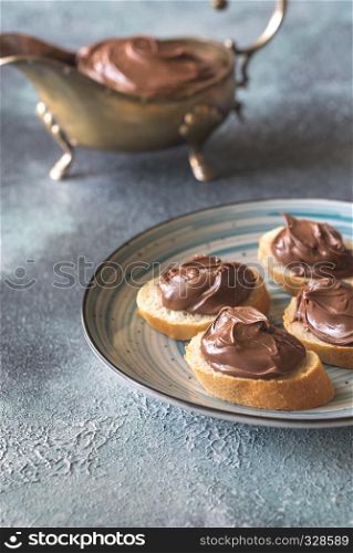 Slices of baguette with chocolate cream on the plate